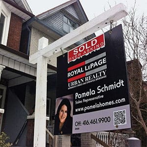 A “SOLD OVER ASKING” Royal LePage Urban Realty sign sits in front of a detached house in North Riverdale, Toronto, Ont. (Rachel Verbin/CP)