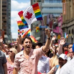 Prime Minister Justin Trudeau waves a flag as he takes part in the annual Pride Parade in Toronto on Sunday, July 3, 2016. THE CANADIAN PRESS/Mark Blinch