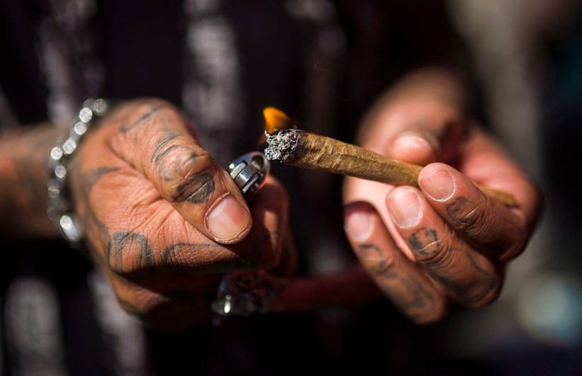 A man lights a marijuana joint during the "420 Toronto" rally in Toronto, Wednesday April 20, 2016. THE CANADIAN PRESS/Mark Blinch
