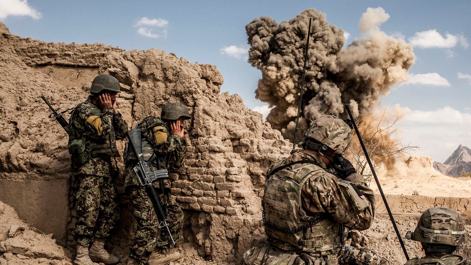 Afghan National Army soldiers, left, and American soldiers from Bravo Company, 3rd Battalion, 1st Armored Division, destroy a Taliban firing position in the Layadira village of Kandahar province, Afghanistan, Feb. 14, 2013. As American troops prepare to speed up their 2014 withdrawal, it is clear some of it will happen under fire, as Taliban fighters try to strike at departing soldiers. (Bryan Denton/New York Times/Getty Images)