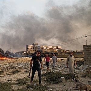 31/08/2016 -- Qayarah, Iraq --
Men inspect burning oil wells on the outskirts of Qayyarah.