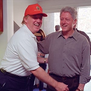 Donald Trump (L) laughs with then U.S. President Bill Clinton at the U.S. Open in Flushing, New York, U.S in this September 8, 2000 handout photo. (Courtesy William J. Clinton Presidential Library/Handout via Reuters)