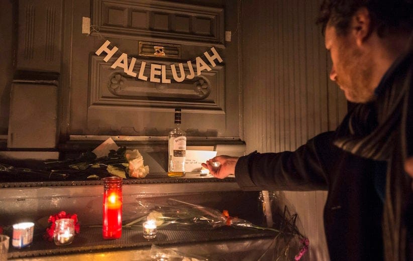 A man lights a candle in front of the home of legendary singer and poet Leonard Cohen Thursday, November 10, 2016 in Montreal. (Paul Chiasson/CP)