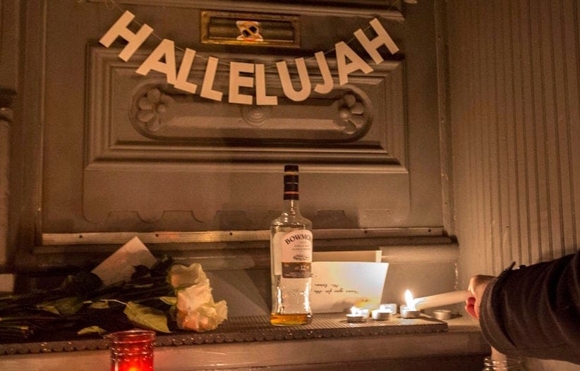 A man lights a candle in front of the home of legendary singer and poet Leonard Cohen Thursday, November 10, 2016 in Montreal. Cohen has died at the age of 82. (Paul Chiasson/CP)