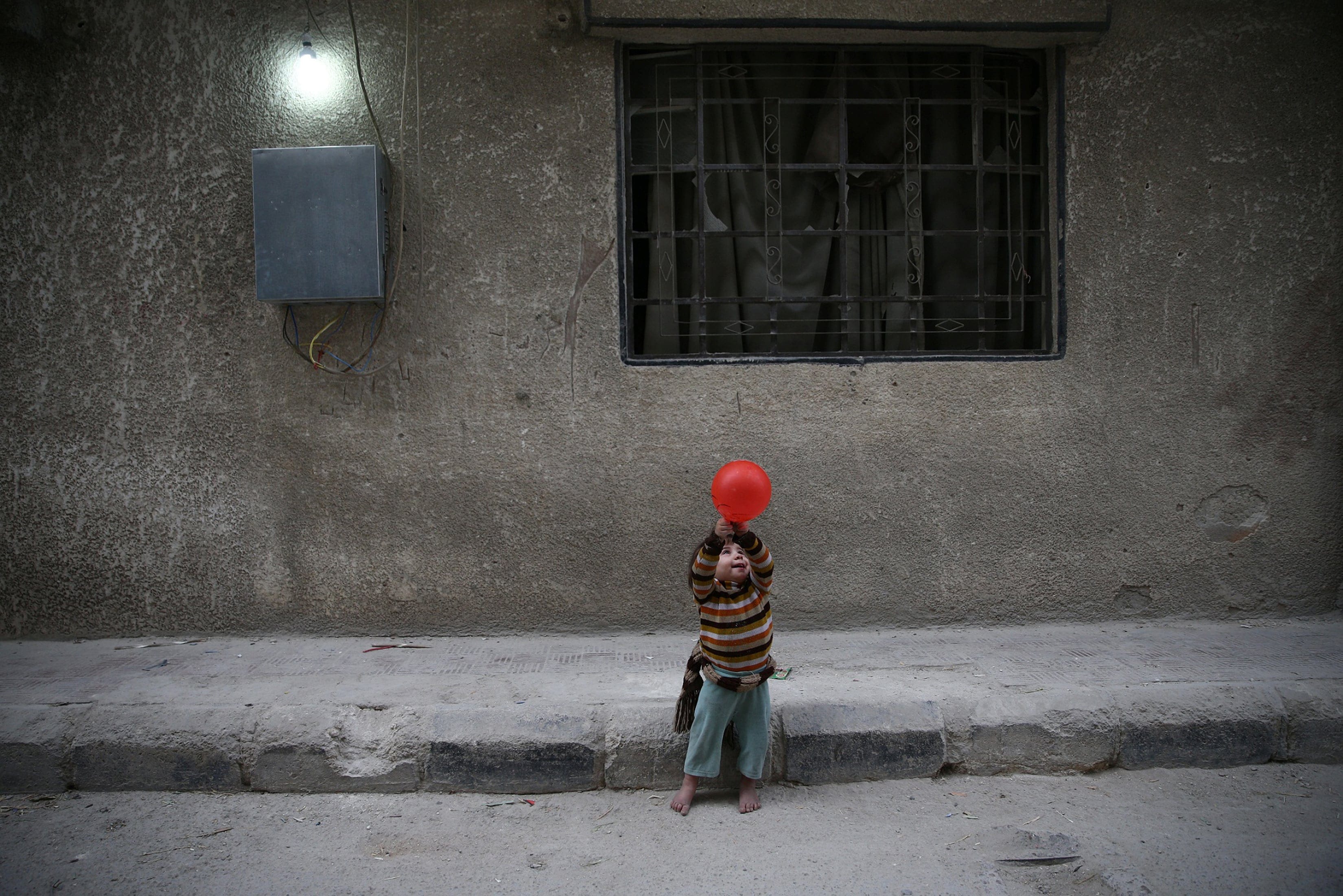 A child plays with a balloon in the rebel-held besieged city of Douma, in the eastern Damascus suburb of Ghouta, Syria November 13, 2016. (Bassam Khabieh/Reuters)