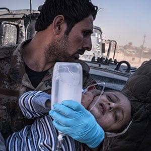 Medics carry a child wounded during fighting to a field hospital on the outskirts of Mosul, Iraq, Nov. 23, 2016. In the battle for Mosul, the last major stronghold of the Islamic State, civilians are paying a growing price, with more and more dead and wounded flowing out of the dense, urban battle zones each day. (Sergey Ponomarev/The New York Times/Redux)
