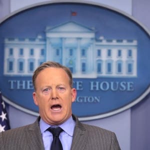 Press Secretary Sean Spicer delivers a statement while television screen show a picture of U.S. President Donald Trump's inauguration at the press briefing room of the White House in Washington U.S., January 21, 2017. (Carlos Barria/Reuters)