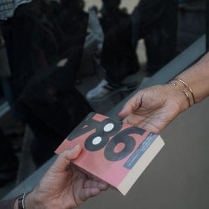 A demonstrator (R) gives George Orwell's book '1984' to a woman outside the Art and Cultural centre during a rally in Bangkok on February 14, 2015. (Nicolas Asfouri/AFP/Getty Images)