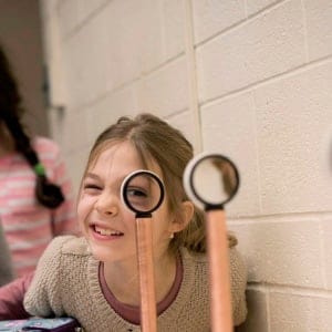 Catherine Makarytchev, 8, right, takes her turn looking through magnifying lenses while performing experiments at a junior science program at the University of Toronto i. (Darren Calabrese/CP)