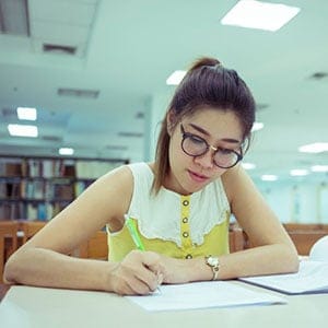 Student in library. (Sutichak/Shutterstock)