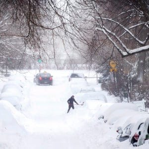 A woman shovels snow from around her car following a winter storm in Montreal, Wednesday, March 15, 2017. (Graham Hughes/CP)