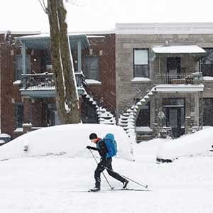 A man cross-country skis past cars buried in snow as a late winter storm that dumped more than two feet (60 cm) of snow in certain areas of Quebec, closed schools and some roadways causing multiple highway collisions and incidents of trapped motorists, in Montreal, Quebec, Canada March 15, 2017. (Dario Ayala/Reuters)