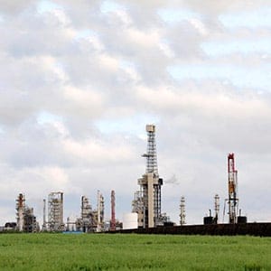An drilling rig, right, at work near the Husky Energy upgrader facility in Lloydminster, Saskatchewan. (Larry MacDougal/CP)