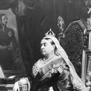 An 1883 painting of Queen Victoria (1819 - 1901), taken from an 1882 photograph by Alexander Bassano. Behind the queen is a portrait of her deceased consort, Prince Albert, by German artist Franz Xaver Winterhalter, and the box beside her is labelled 'First Lord of the Treasury'. (Hulton Archive/Getty Images)