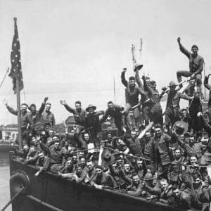 A group of American soldiers wave heartily from the deck of a ship transporting them to the fighting in France, during World War I, 1917. (Interim Archives/Getty Images)