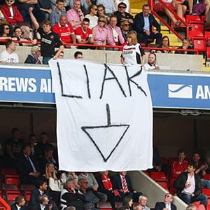 Charlton Athletic fans hold a banner saying "Liar" and an arrow pointing to the directors box in protest against Roland Duchatelet owner of Charlton Athletic during the Sky Bet Championship match between Charlton Athletic and Burnley at The Valley on May 7, 2016 in London, United Kingdom. (Catherine Ivill/AMA/Getty Images)