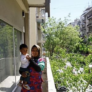 A refugee woman stands with her baby at the balcony of City Plaza hotel reopened for refugees by an organization which support refugees in Athens Greece on April 26, 2016.
(Ayhan Mehmet/Anadolu Agency/Getty Images)