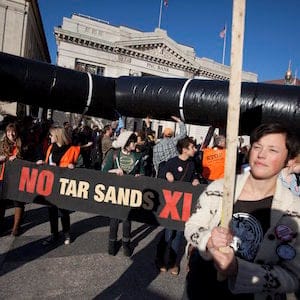 Demonstrators march with a replica of a pipeline during a protest to demand a stop to the Keystone XL tar sands oil pipeline outside the White House on Sunday, Nov. 6, 2011, in Washington. (AP Photo/Evan Vucci)