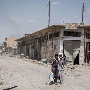 A man helps an elderly man walk into Iraqi government controlled territory in Mosul, Iraq on June 20, 2017. (Photograph by Cengiz Yar)