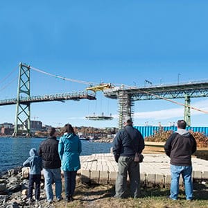 Spectators watch as workers place a new section of the deck for the Angus L. Macdonald Bridge spanning the harbour in Halifax on Saturday, October 31, 2015. The project is called The Big Lift and involves replacement of the suspended spans of the structure. Commuters have faced nightly and weekend closures and delays travelling between Halifax and Dartmouth. (Andrew Vaughan/CP)