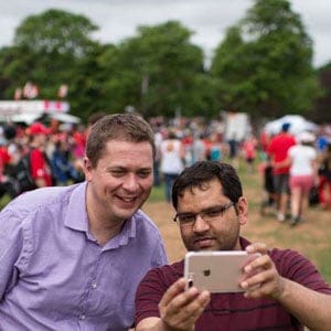 Conservative Party Leader Andrew Scheer, left, takes a selfie with a supporter during Canada Day festivities in Charlottetown, P.E.I. on Saturday, July 1, 2017. (Photograph by Darren Calabrese