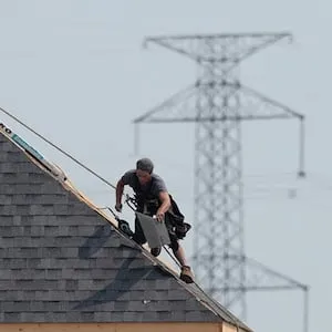 A construction worker shingles the roof of a new home in a development in Ottawa on Monday, July 6, 2015. Experts say measures introduced by the Ontario government to cool the red-hot housing market are likely to leave a lot of the buyers on the sidelines as they await to see the impact of the changes. THE CANADIAN PRESS/Sean Kilpatrick