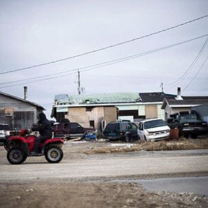 A man rides his ATV in the northern Ontario First Nations reserve in Attawapiskat, Ont., on Tuesday, April 19, 2016. In many ways, Attawapiskat - population 2,100 - has all the trappings of any small town, including older folk lamenting the changing of the times. (Nathan Denette/CP)