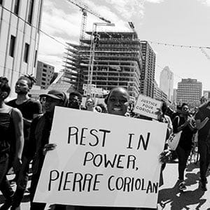 July 02 2017 -- Venetta Gordon of Black Lives Matter Montreal holds up a sign in solidarity to Pierre Coriolon a 58 year old Black man whom was tasered, shot by rubber bullets and then shot dead by Montreal Police June 27th 2017. (Jalani Morgan)