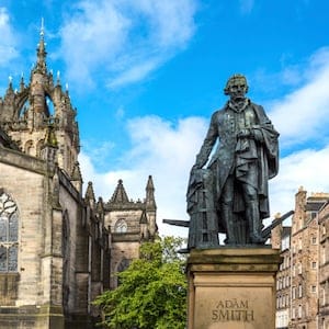 Edinburgh, United Kingdom - July 28, 2012: The monument of Adam Smith and the apse of the St Giles cathedral on the Royal Mile