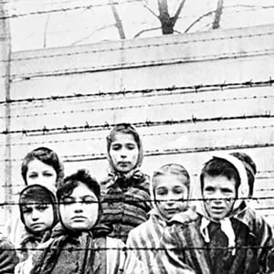 A group of child survivors behind a barbed wire fence at the Nazi concentration camp at Auschwitz-Birkenau in southern Poland. (Alexander Vorontsov/Galerie Bilderwelt/Getty Images)