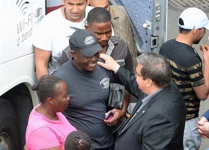 Montreal Mayor Denis Coderre, bottom right, greets newly-arrived asylum seekers at a reception area at the Olympic Stadium, in Montreal on Thursday, August 3, 2017. The city of Montreal has opened a new temporary shelter for asylum seekers in a building that once housed a convent. THE CANADIAN PRESS/Ryan Remiorz