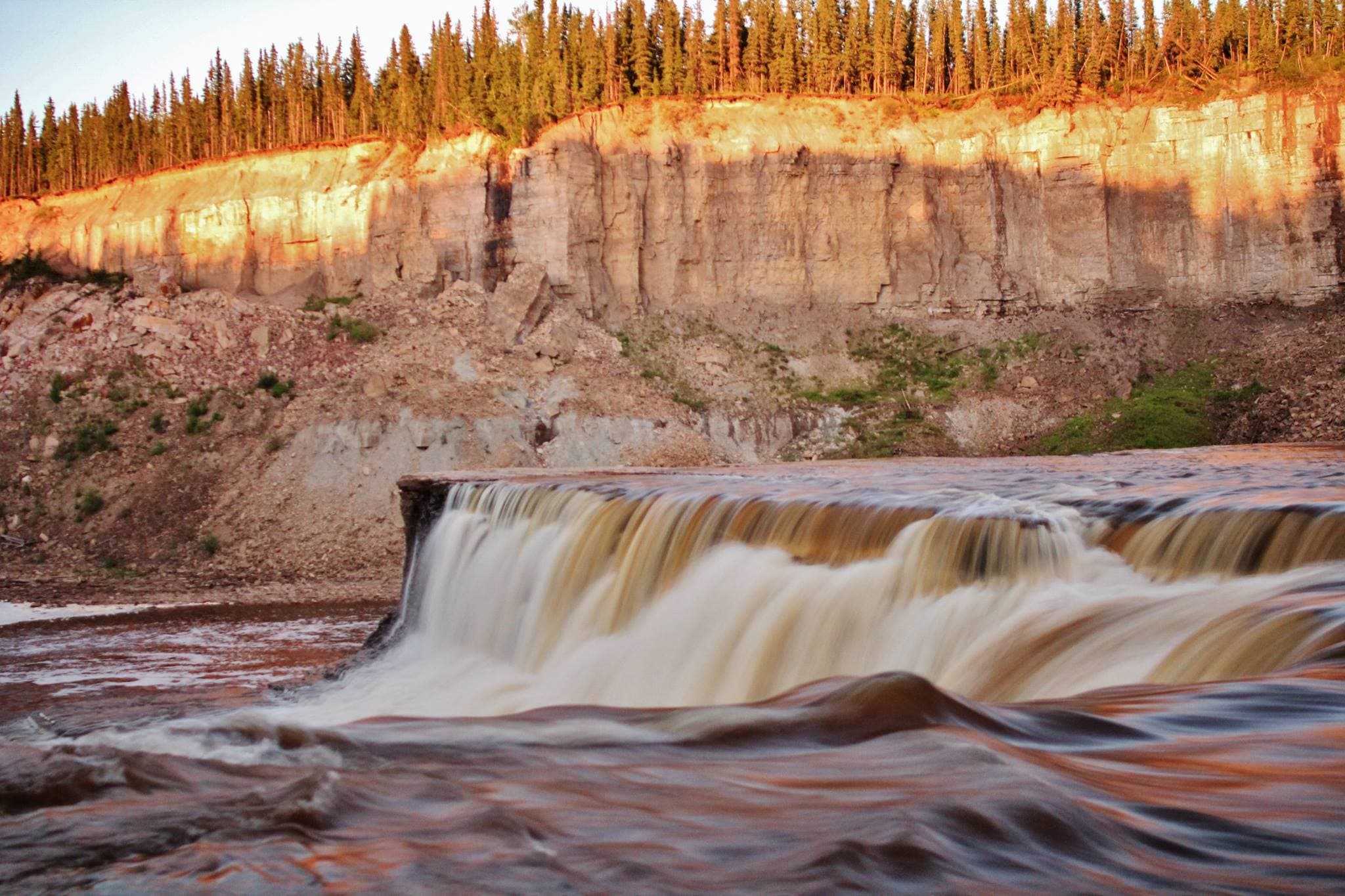 This photo is of Louise Falls in Twin Gorge Territorial Park, Northwest Territories. Because it was June when it was taken, I made everyone in our group wait until 10 pm before starting the trek down the 138 step spiral staircase to the falls. All in the hopes of capturing the falls during sunset.