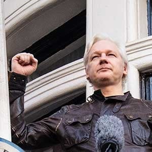 LONDON, ENGLAND - MAY 19: Julian Assange puts his fist in the air as he steps out to speak to the media from the balcony of the Embassy Of Ecuador on May 19, 2017 in London, England. Julian Assange, founder of the Wikileaks website that published US Government secrets, has been wanted in Sweden on charges of rape since 2012. He sought asylum in the Ecuadorian Embassy in London and today police have said he will still face arrest if he leaves. (Photo by Jack Taylor/Getty Images)