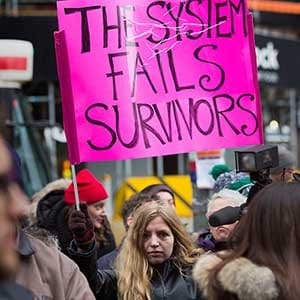 TORONTO, ON - MARCH 24, 2016 Cecilia, who declined to give her last name holds a placard in support during a rally. The Ryerson Unversity's Centre for Women and Trans People staged a rally at Old City Hall in response to Ghomeshi verdict and to show support for the #WeBelieveSurvivors and #IBelieveSurvivors movement. Chris So/Toronto Star/Getty Images