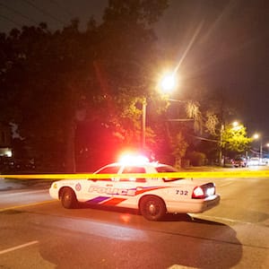A man watches on at a crime scene following a shooting in Scarborough, a suburb in east Toronto, July 17, 2012. Two people were killed and at least 19 injured in a shooting at an outdoor party in Toronto, police said on Tuesday, raising fresh fears of a rise in gun crime in Canada's largest city. REUTERS/Mark Blinch (CANADA - Tags: CRIME LAW) - GM1E87H18W101