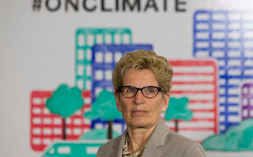 Ontario Premier Kathleen Wynne listens to questions from the media during an announcement which outlined a cap and trade deal with Quebec aimed at curbing green house emissions, in Toronto on Monday, April 13 2015. The plan involves government-imposed limits on emissions from companies, and those that want to burn more fossil fuels can buy carbon credits from those that burn less than they are allowed. THE CANADIAN PRESS/Chris Young