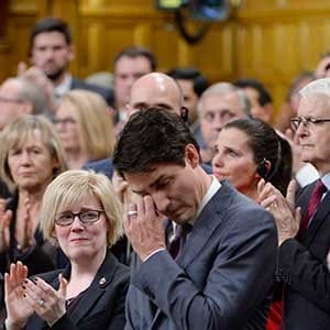 Prime Minister Justin Trudeau wipes his eye while he is applauded while making a formal apology to individuals harmed by federal legislation, policies, and practices that led to the oppression of and discrimination against LGBTQ2 people in Canada, in the House of Commons in Ottawa, Tuesday, Nov.28, 2017. THE CANADIAN PRESS/Adrian Wyld