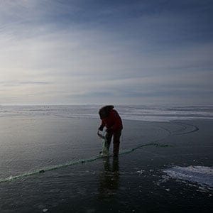 Clint Beardy, a resident of Lake St Martin First Nation, fishes on the lake December 2, 2017. Beardy and his family refused to evacuate when flood waters consumed the town. (Photograph by John Woods)