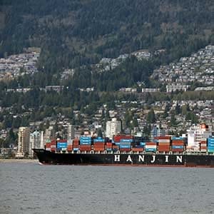 Vancouver, Canada - April 18, 2014: Hanjin cargo vessel leaving Vanouver harbour with various commercial shipping containers on board