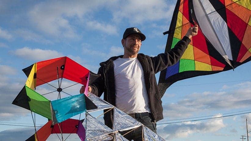 Neil Parman holds several of his kites in Beban Park, Nanaimo. (Photograph by Jen Osborne)