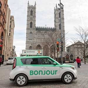 A taxi with Bonjour on the side drives past the Notre-Dame Basilica in Montreal on Thursday, November 30, 2017. The National Assembly is formally asking Quebec's merchants to "warmly" greet their clients with the word "Bonjour," and drop the old standard "Bonjour-hi." THE CANADIAN PRESS/Ryan Remiorz