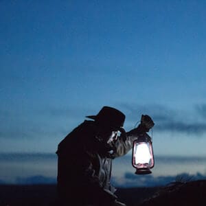 Cowboy on horse with lantern at dusk