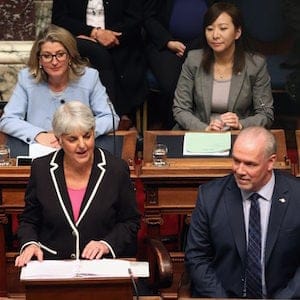 Attorney General David Eby, (left), and Premier John Horgan look on as Finance Minister Carole James delivers the budget speech from the legislative assembly at Legislature in Victoria, B.C., on Tuesday, February 20, 2018. THE CANADIAN PRESS/Chad Hipolito