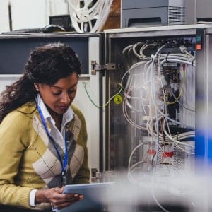 One woman checking on network servers using a digital tablet.