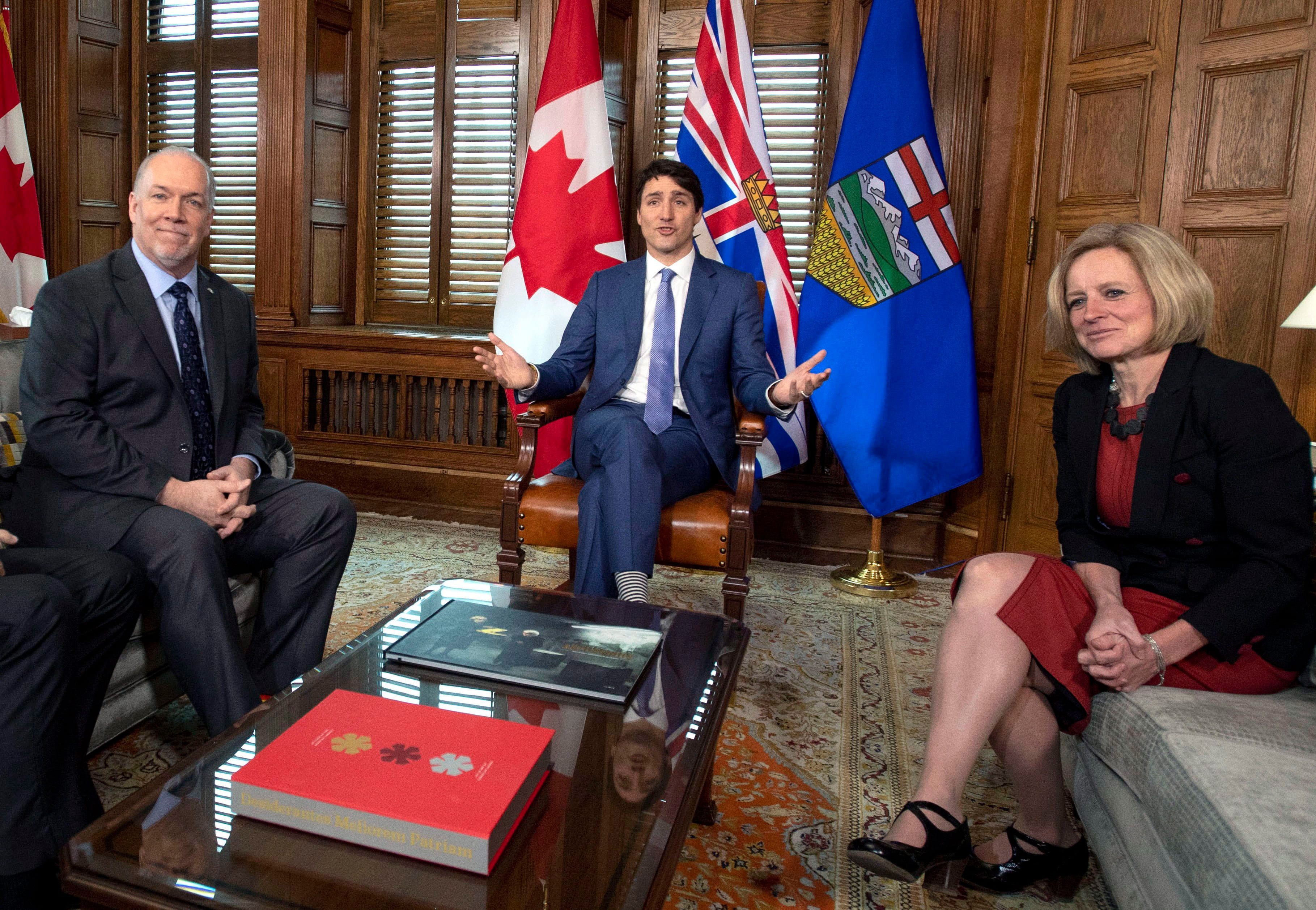 Prime Minister Justin Trudeau speaks before a meeting on the deadlock over Kinder Morgan's Trans Mountain pipeline expansion with B.C. Premier John Horgan, left, and Alberta Premier Rachel Notley, in his office on Parliament Hill in Ottawa on Sunday, April 15, 2018. THE CANADIAN PRESS/Justin Tang