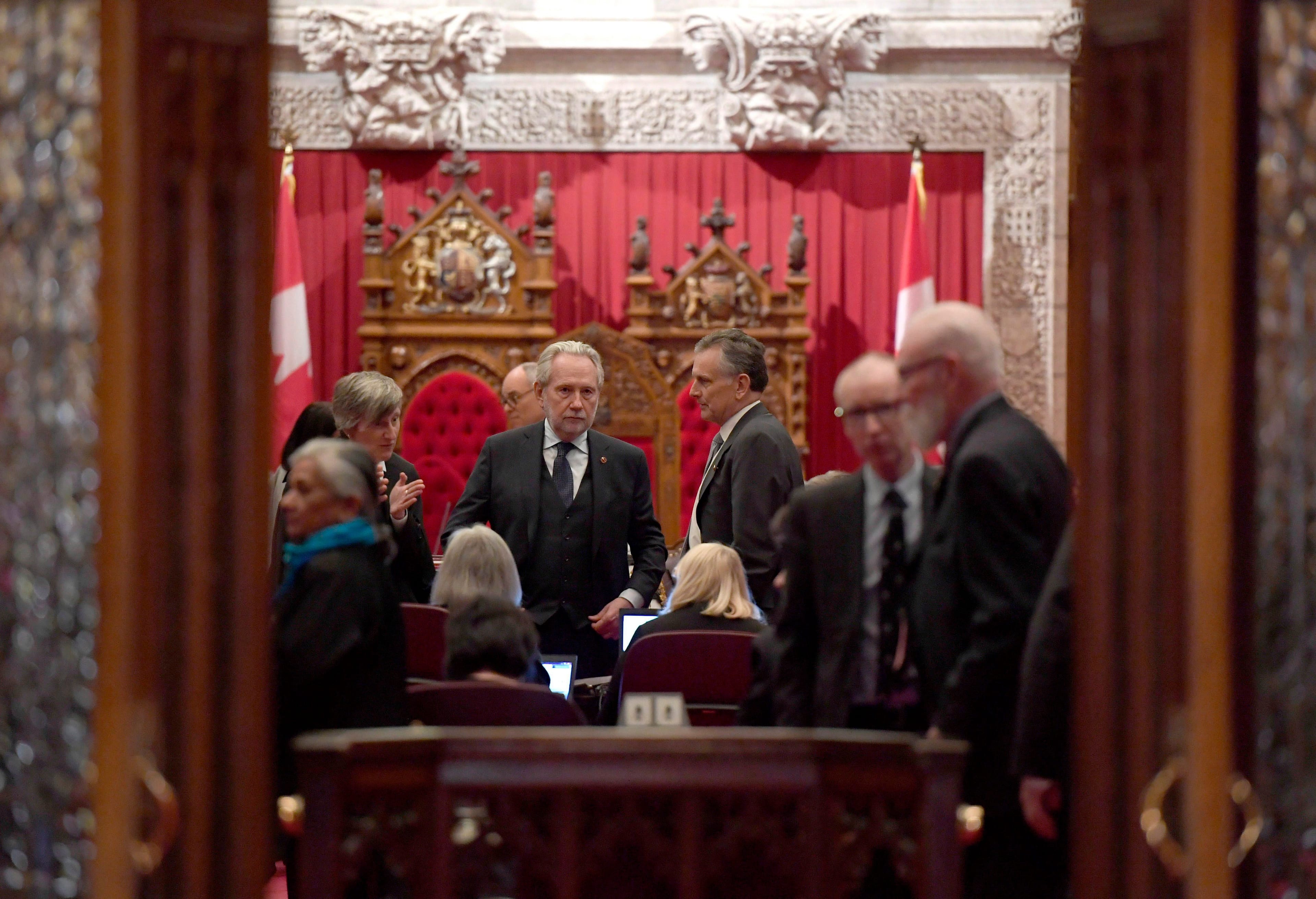 Sen. Peter Harder, government representative in the Senate, left, speaks with Sen. Larry Smith, leader of the opposition in the Senate, before a vote on Bill C-45, the Cannabis Act, in the Senate chamber on Parliament Hill in Ottawa on Thursday, March 22, 2018. (THE CANADIAN PRESS/Justin Tang)