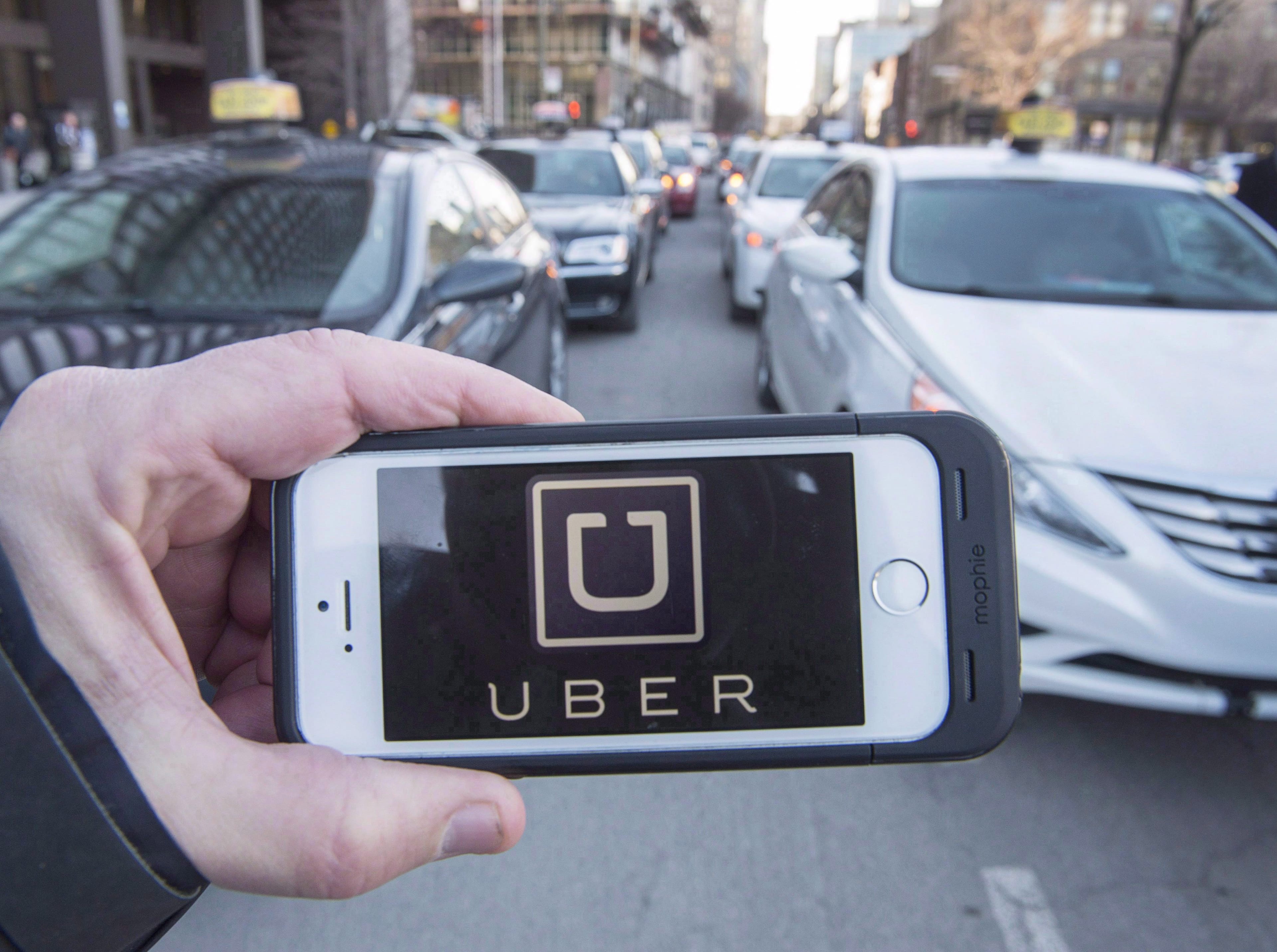 The town of Innisfil and Uber have signed a deal to expand their partnership by adding two new flat fare destinations. They say rides to the Innisfil ideaLAB and Library as well as the South Innisfil Community Centre will be $3. The Uber logo is seen in front of protesting taxi drivers at the courthouse in Montreal on Tuesday, February 2, 2016. (Ryan Remiorz/CP)