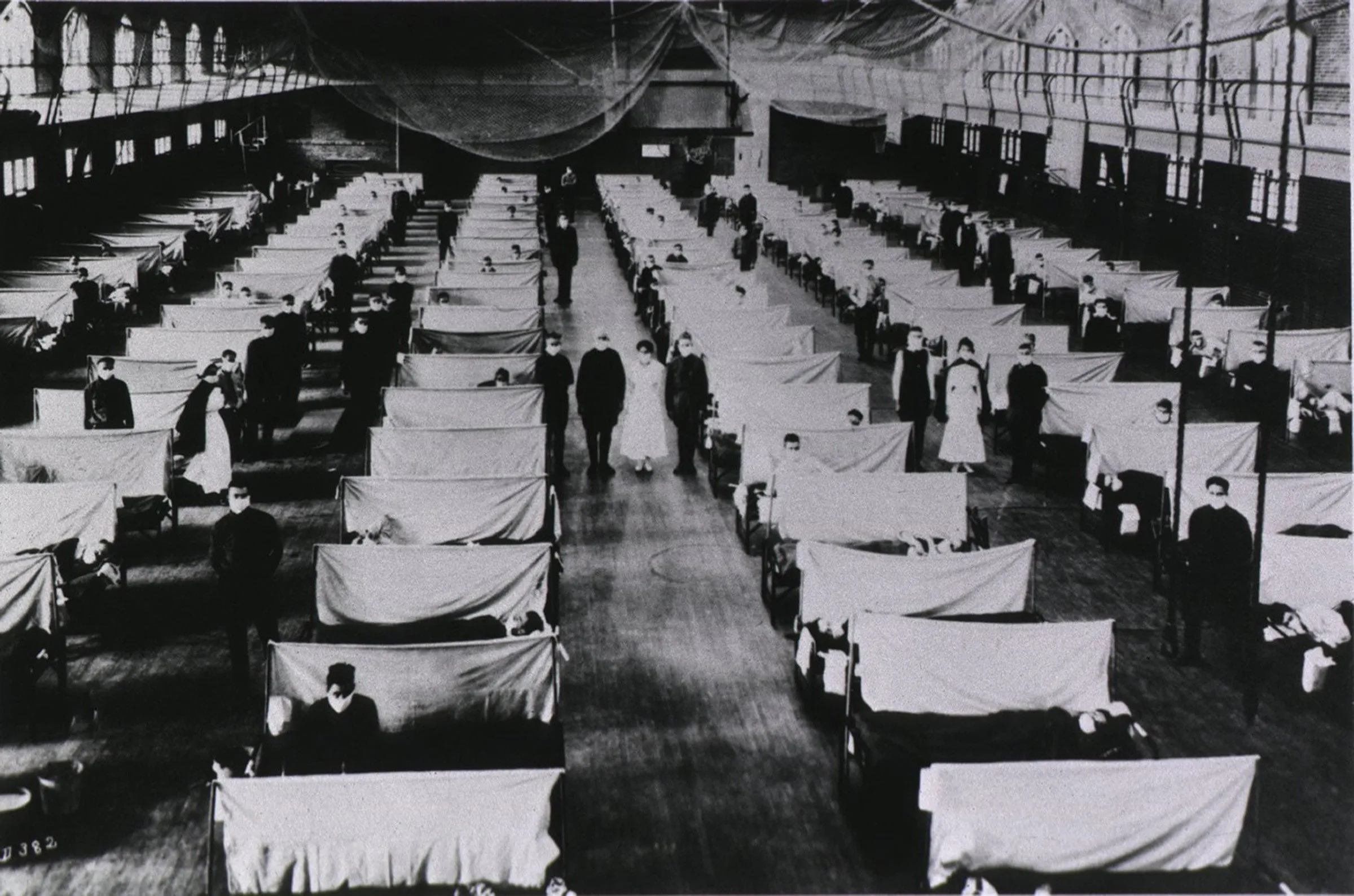 Spanish Flu Epidemic 1918-19. U.S. school gymnasium converted into an flu ward with patients' beds are separated by screens and masked health workers. An estimated 25% of the US population contracted the flu and over 500,000 died. (CP/Courtesy of Everett Collection)