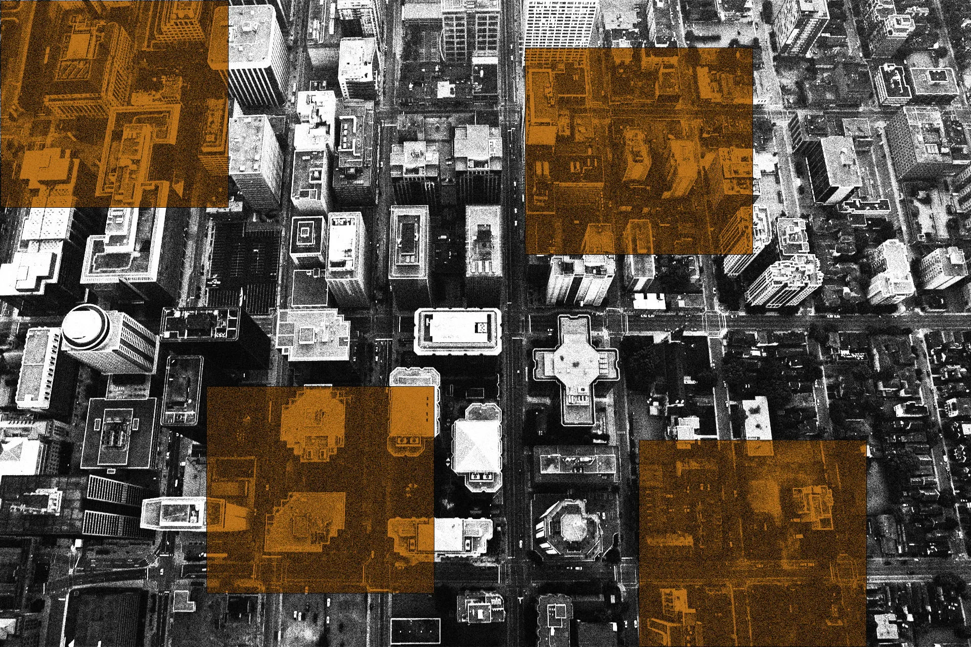 Black and white aerial shot of tall city buildings, with rusty orange squares overtop.