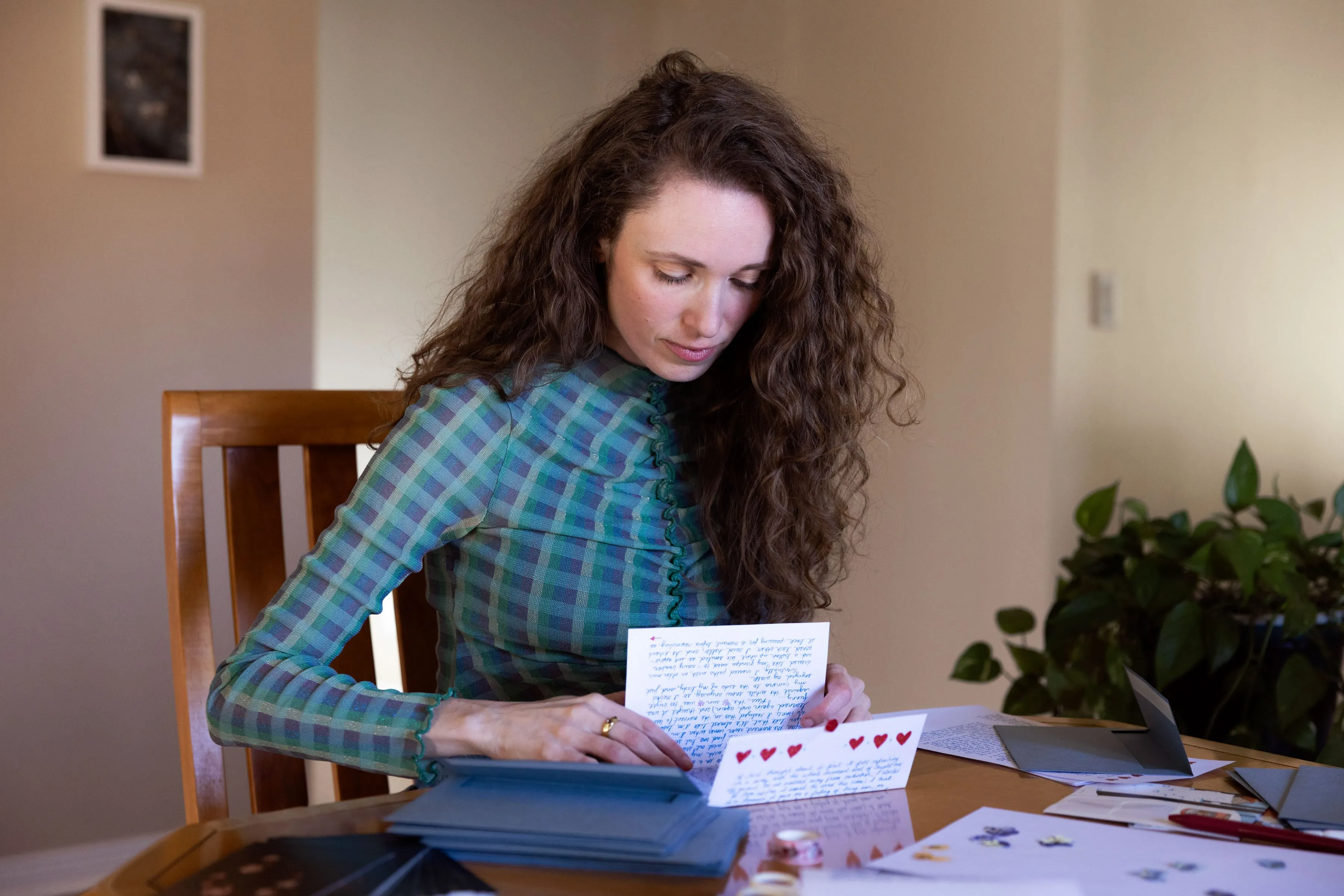 A woman with curly hair reading a letter